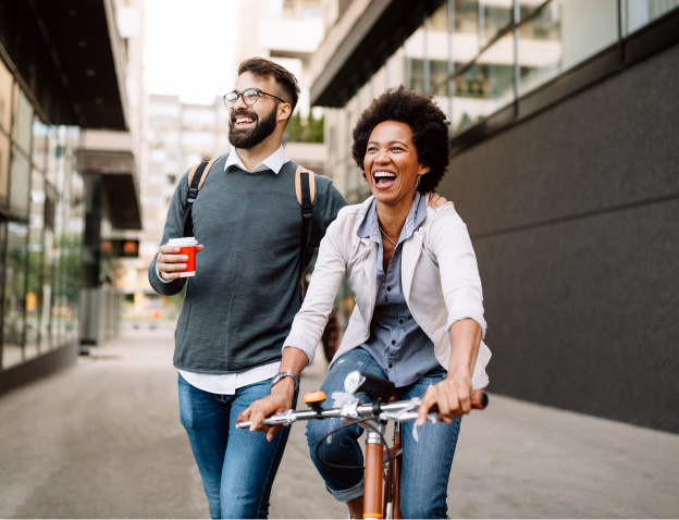 A man walking beside a woman on a bike