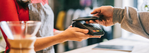 Barista with credit card device taking payment from customer