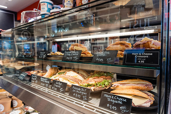 A fine selection of deli sandwiches in a glass showcase.